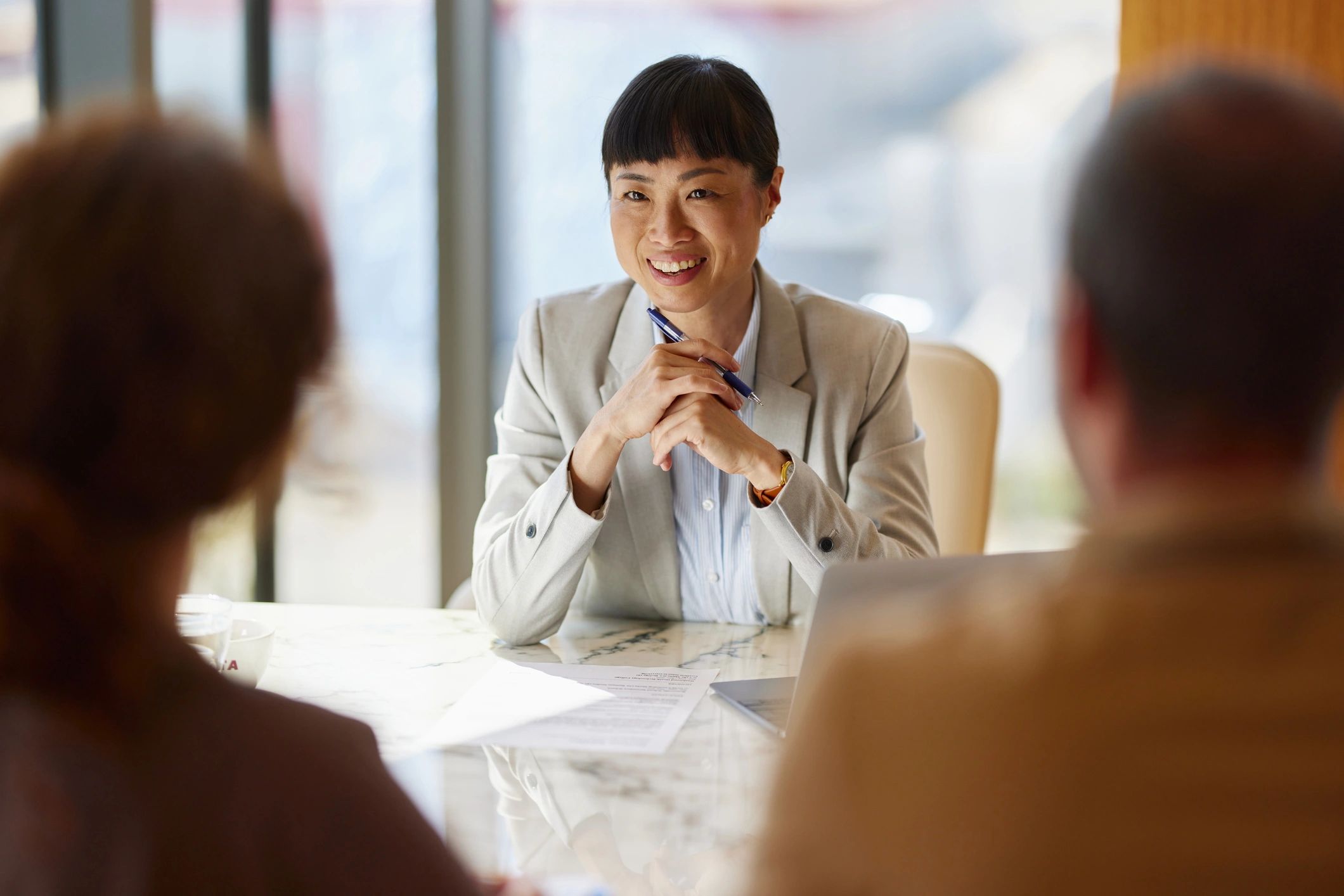 Advisor meeting with clients at a desk reviewing documents